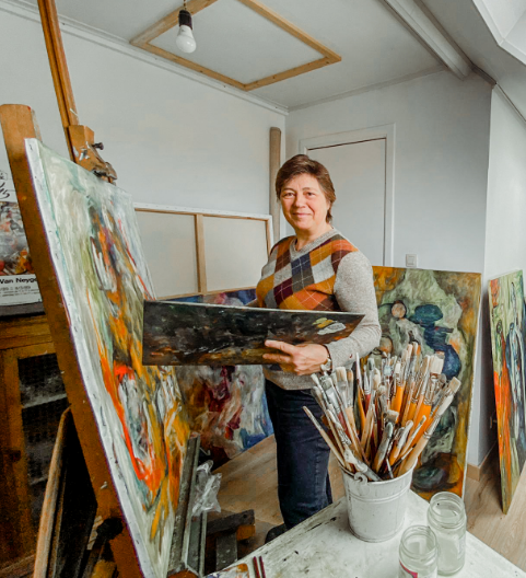 Marijke aan het werk bij de schildersezel in haar atelier